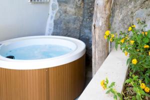 a hot tub sitting on a ledge next to a plant at o' mar - Amalfi Coast Suite in Praiano