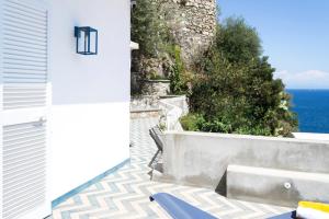 a balcony with a bench and the ocean in the background at o' mar - Amalfi Coast Suite in Praiano