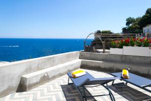 two chairs and a table on a patio overlooking the ocean at o' mar - Amalfi Coast Suite in Praiano