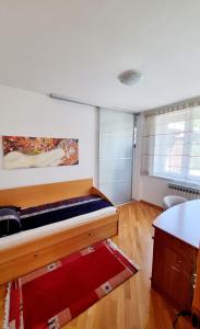 a bedroom with a bed with a painting on the wall at nafaka apartment 90m2 in Sarajevo