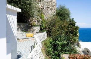 a stairway with a white bench next to the ocean at o' mar - Amalfi Coast Suite in Praiano