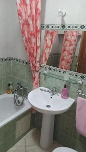 ein Badezimmer mit einem Waschbecken, einem WC und einem Spiegel in der Unterkunft Apartment soultana in Tangier