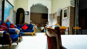 Exquisite Riad Beach & Surf في الرباط: غرفة معيشة مع كراسي زرقاء وجدار