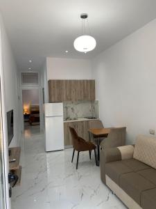 a kitchen and living room with a couch and a table at Pogradeci Apartments in Pogradec
