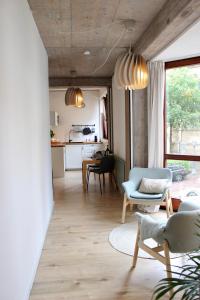 a living room with two chairs and a kitchen at Vier Sind Hier Apartments in Rottweil