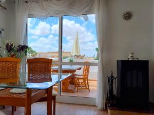 a dining room with a glass table and a sailboat in the window at Villa de Lagos Coloridos in Los Montesinos