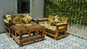 dwa krzesła i stolik kawowy przed ścianą w obiekcie Exquisite Riad Beach & Surf w mieście Rabat