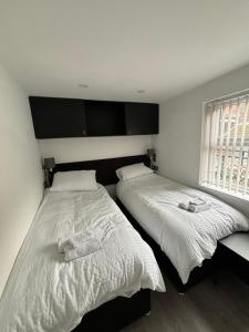 een slaapkamer met twee bedden en een raam bij Williamson Suites - Apartment 1 in Liverpool