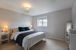 a bedroom with a white bed with green pillows at Modern 2 Bed Apartment Near Gatwick in Crawley