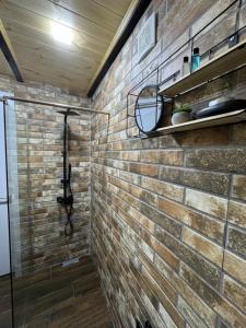 a bathroom with a brick wall and a shelf at Machakhela cottage in Batumi