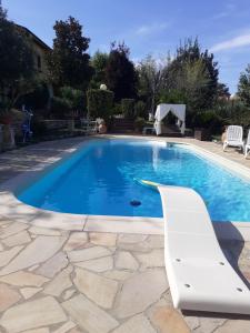 a swimming pool with a white chair next to it at casavacanze Baggioro in Colle di Compito
