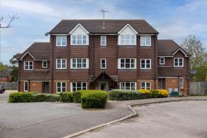 a large brown brick house with white windows at Modern 2 Bed Apartment Near Gatwick in Crawley