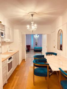 uma cozinha com uma mesa e cadeiras azuis em Charming Apartment Chateau Versailles City Center em Versailles