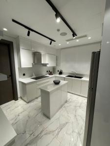 a kitchen with white cabinets and a marble floor at Down Town New ELalamein خلف الابراج وبجوار فندق ريكسوس العلمين in El Alamein