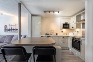 een keuken en een woonkamer met een tafel en stoelen bij Modern 2 Bed Apartment Near Gatwick in Crawley