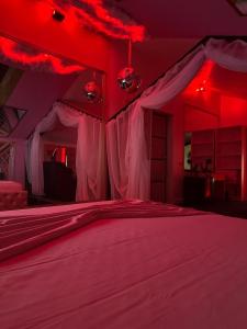 una camera da letto con un letto con luci rosse sopra di Hotel Boutique18plus - Adults Only a Mamaia Nord - Năvodari