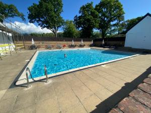 a swimming pool with a person in the water at Red Squirrel Lodge in Sandown