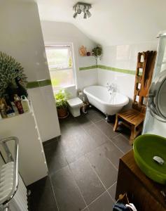 a bathroom with a tub and a sink at Pond Cottage in Purley