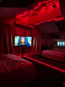 una stanza con una tv in una stanza con luci rosse di Hotel Boutique18plus - Adults Only a Mamaia Nord - Năvodari Altre 35 foto