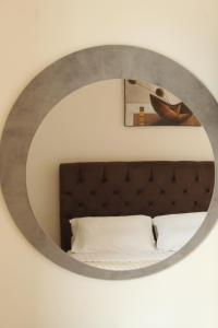 a mirror above a bed in a bedroom at Sofotel in Koroni