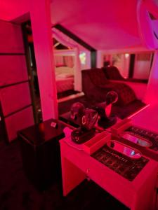 a room with a pink room with a bed and a desk at Hotel Boutique18plus - Adults Only in Mamaia Sat/Năvodari