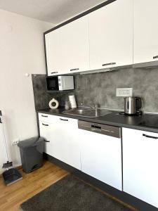 een keuken met witte kasten en een wastafel bij Apartman Lara Laktasi in Laktaši