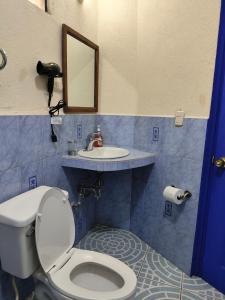 een badkamer met een toilet en een wastafel bij Hotel Restaurante La Villa de los Dioses in San Antonio Palopó