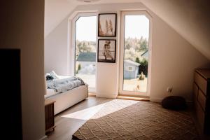 a bedroom with a bed and a large window at Prawdziwe Morze in Sasino