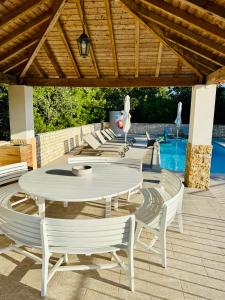 Un patio con mesa y sillas y una piscina. en Quinta Boa Vida, en Alcobaça