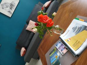 a vase of flowers on a table in a living room at Ty'brestoise proche centre - jardin- parking gratuit in Brest