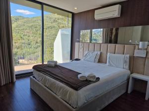 a bedroom with a large bed with a large window at DOBAU village in Vieira do Minho +93 photos