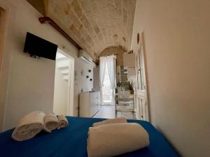 une chambre avec un lit bleu avec des serviettes dessus dans l'établissement Casa Maya, Vista Mare e Relax, à Polignano a Mare