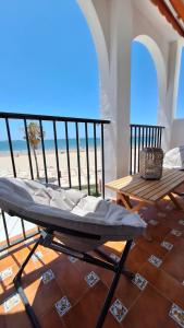 uma cama e uma mesa num quarto com praia em TU DENSCANSO EN VALDELAGRANA FRENTE AL MAR em El Puerto de Santa María