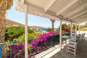 a patio with purple flowers and a fence at Be Kythnos in Mérikhas