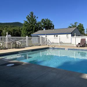 a swimming pool in front of a white fence at North Colony Motel and Cottages in Bartlett