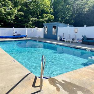 a swimming pool with blue water in a yard at North Colony Motel and Cottages in Bartlett