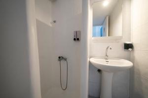 a white bathroom with a sink and a shower at Be Kythnos in Mérikhas +52 photos