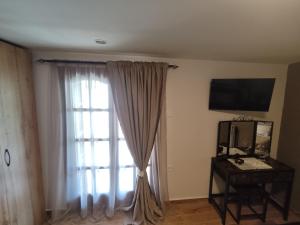 una habitación con una ventana y una mesa con espejo en Pelion bee guesthouse, en Portaria 7 fotos más