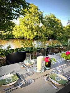 a table with glasses and napkins and a view of a river at Château de La Tour en Brenne in Rivarennes