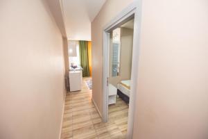 um corredor que leva a uma casa de banho com espelho em Palvan Hotel em Antalya