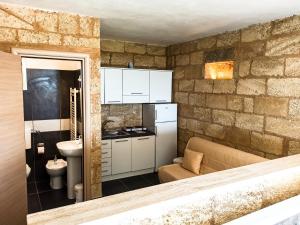 a kitchen with a couch and a sink in a room at Li Monaci - GALLIPOLI - EcoBio RELAIS in Gallipoli