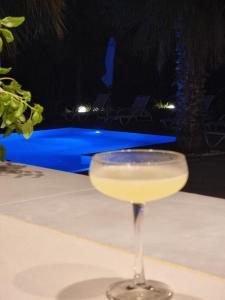 un drink in un bicchiere di vino seduto su un tavolo di Pine Resort a Polykhrono