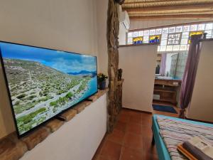een flatscreen-tv aan een muur in een kamer bij Casa Olive in San Vito