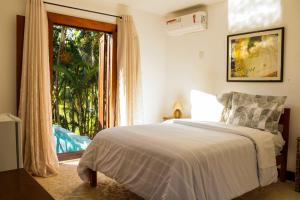 una camera da letto con un letto e una grande finestra di Casa Barco Ferradura - Pousada a Búzios Altre 157 foto