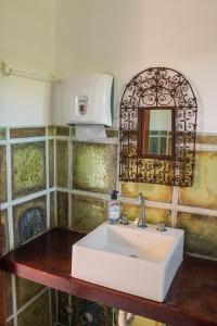 un bagno con un lavandino bianco e uno specchio di Casa Barco Ferradura - Pousada a Búzios