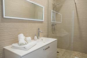 uma casa de banho branca com um lavatório e um chuveiro em Appartement spacieux et rénové em Paris