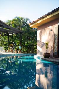 una piscina davanti a una casa di Casa Barco Ferradura - Pousada a Búzios