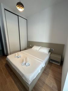 Un dormitorio con una cama con zapatillas. en Pristina Select Apartments, en Pristina