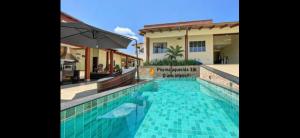 a swimming pool in front of a house at Linda Casa na EPTG com lazer completo - Brasília in Brasilia