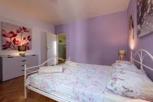 Schlafzimmer mit lila Wänden und einem Bett in der Unterkunft Spacious City Center apartment - 4 pax in Dubrovnik